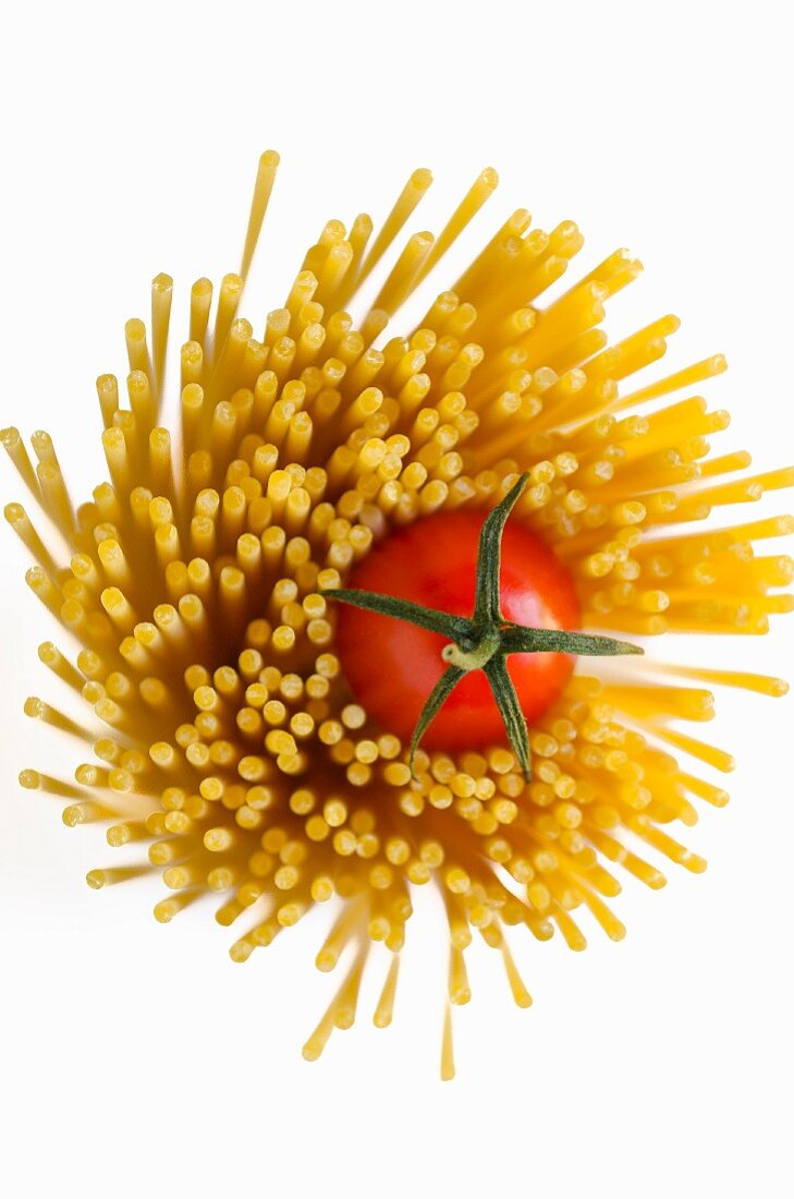A bunch of spaghetti with a cherry tomato