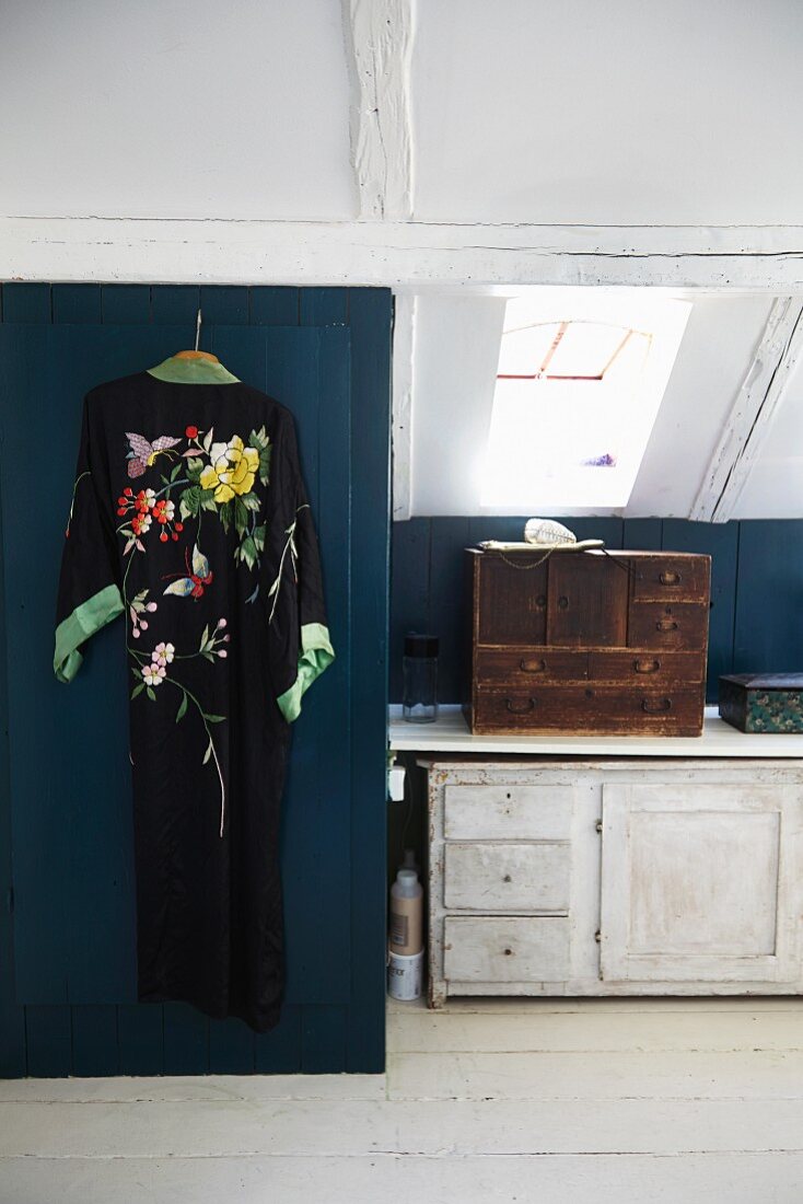 Kimono hung on blue wooden door in vintage attic room