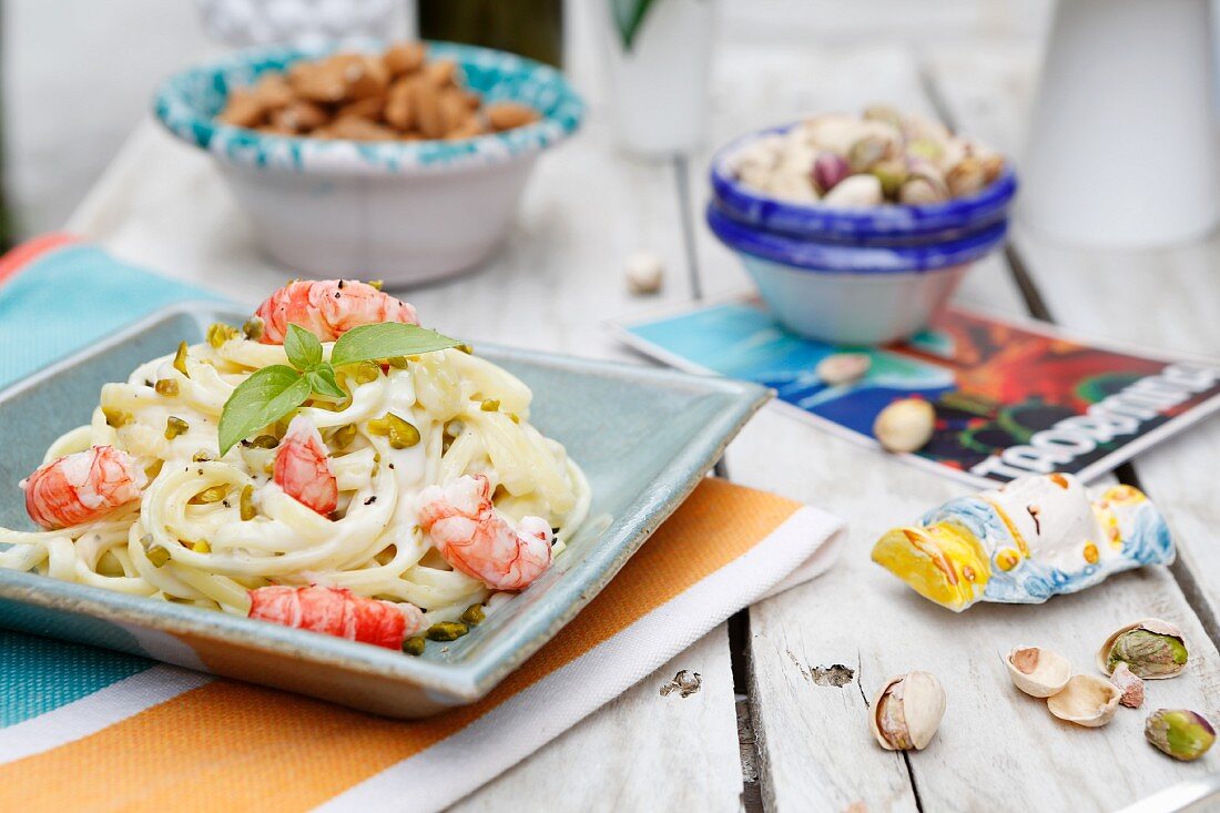 Fettuccini with cream cheese, pistachios, almonds, red prawns and fresh basil (Sicily, Italy)