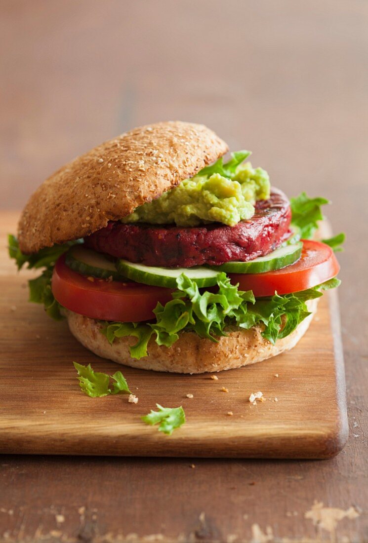 A veggie burger with a beetroot patty and avocado spread