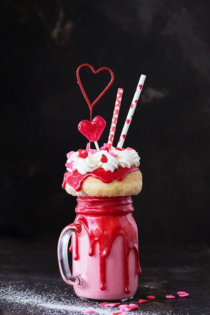 A Valentine's Day freak shake with a mini doughnut and a heart-shaped lolly