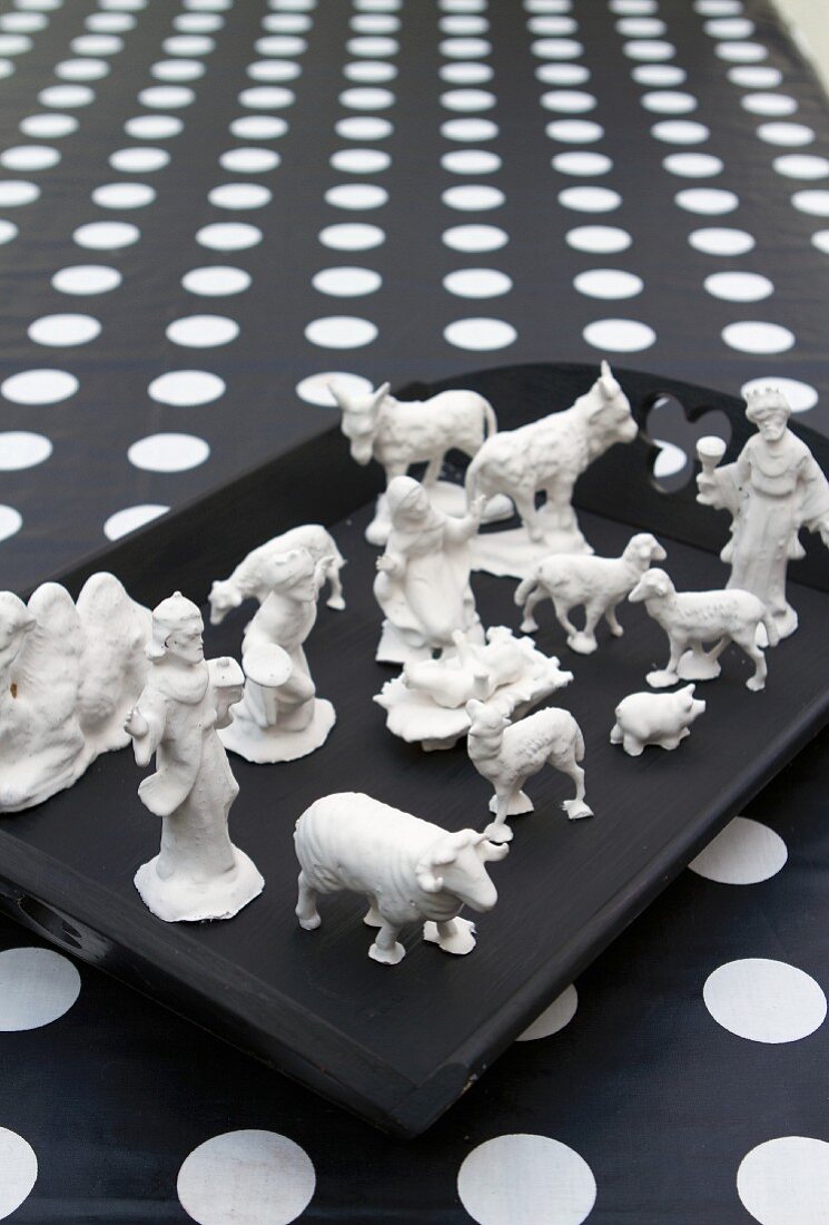 Christmas crib figurines dipped in plaster on black tray