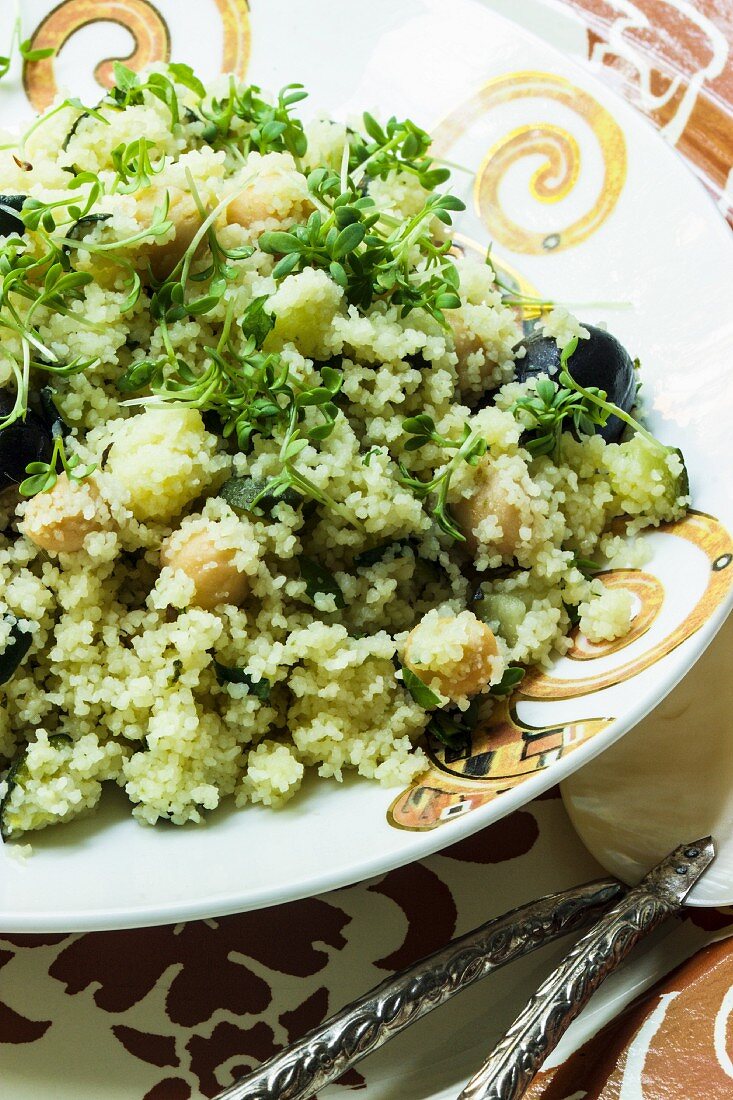 Vegan couscous with chickpeas, olives and cress