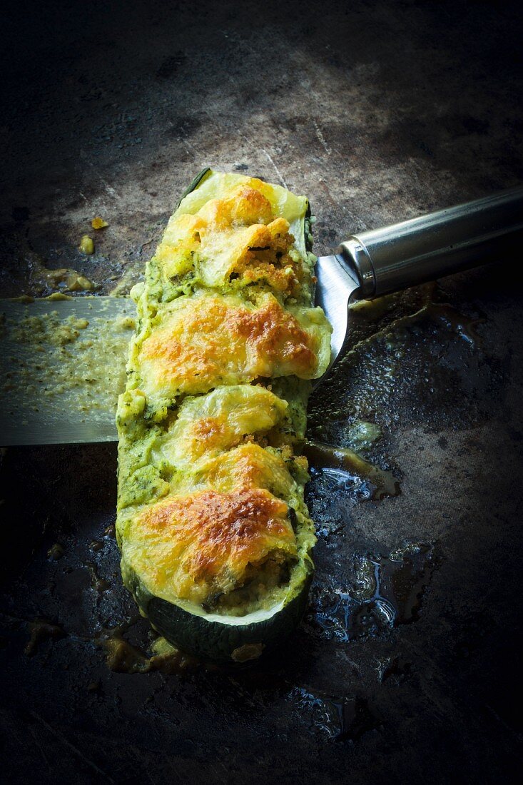 Gratinated courgette with a vegetable filling on a dark surface
