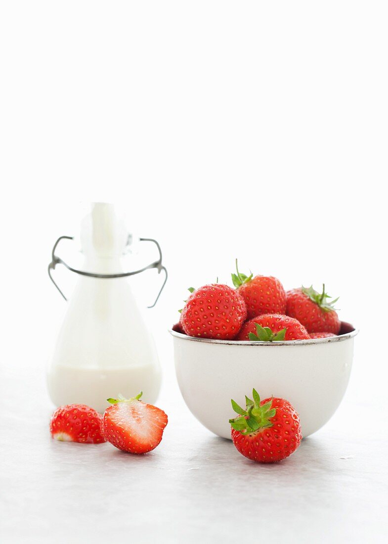 Fresh strawberries and a bottle of cream