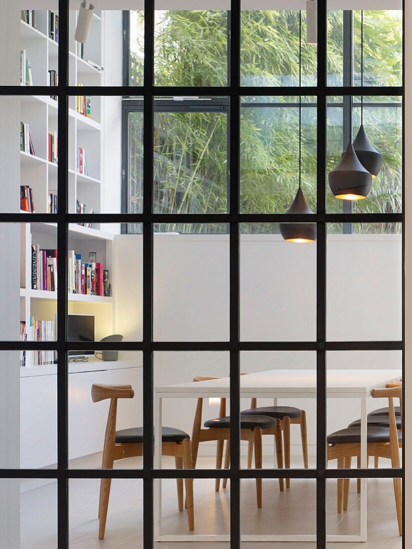 Blick duch Sprossenfenster auf Esszimmer mit modernen Möbeln