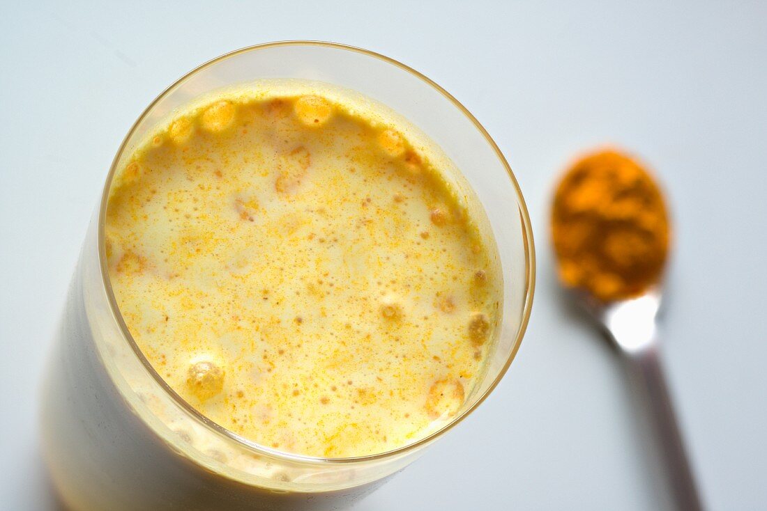 Golden milk: a milk drink with almond milk and turmeric in a glass