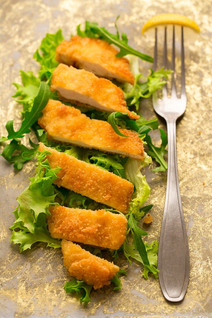 A gluten-free chicken escalope on a bed of lettuce