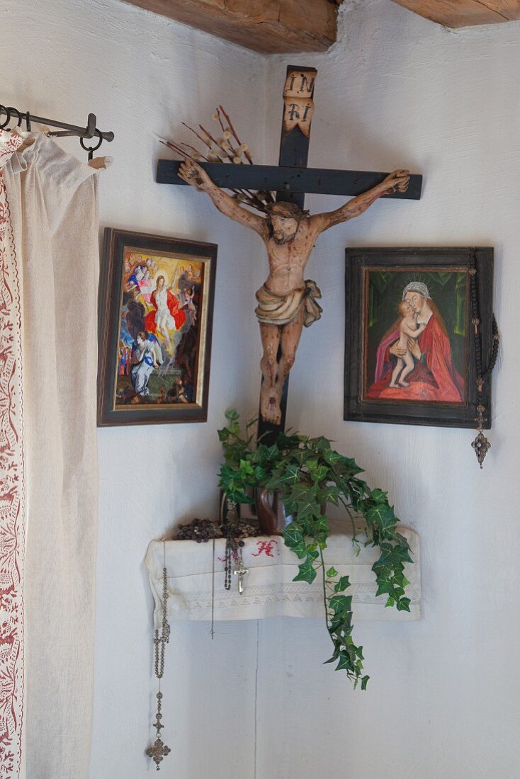Kruzifix und christiliche Bilder im traditionellen Herrgottswinkel