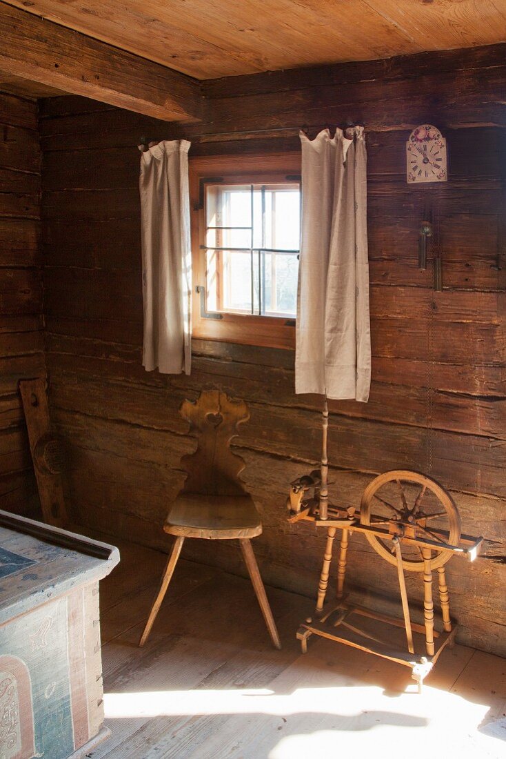 Bauernstuhl und ein altes Spinnrad im Bauernhaus