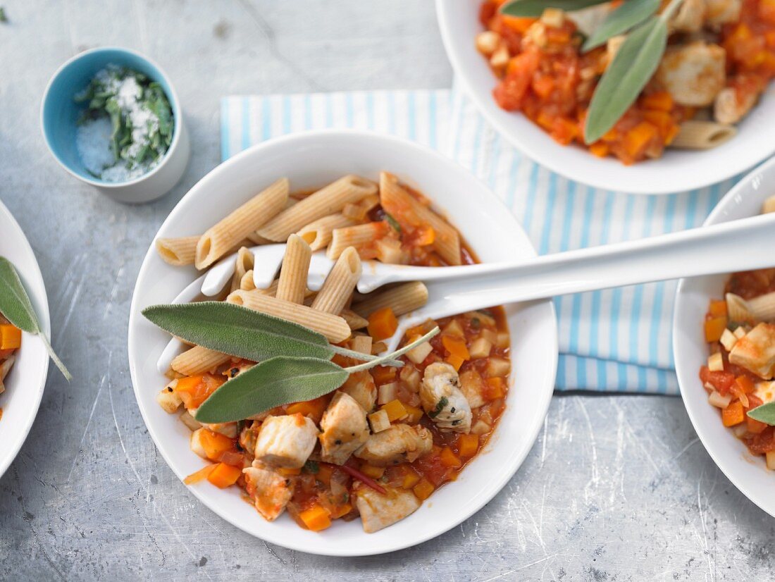 Pasta with chicken filet, tomatoes, carrot and sage