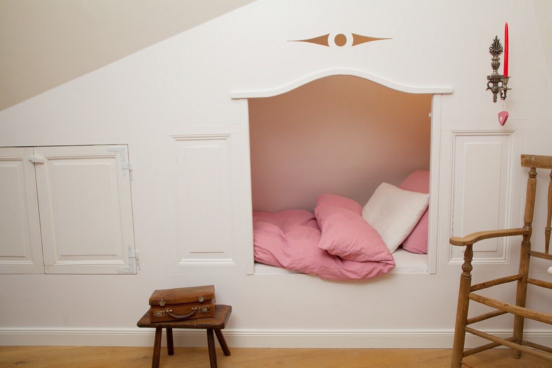 Traditional cubby bed with shutters under sloping ceiling