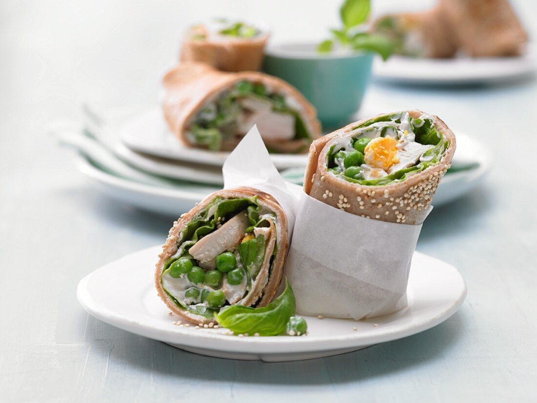 Pancake wraps with chicken, peas, egg, lettuce and sesame seeds