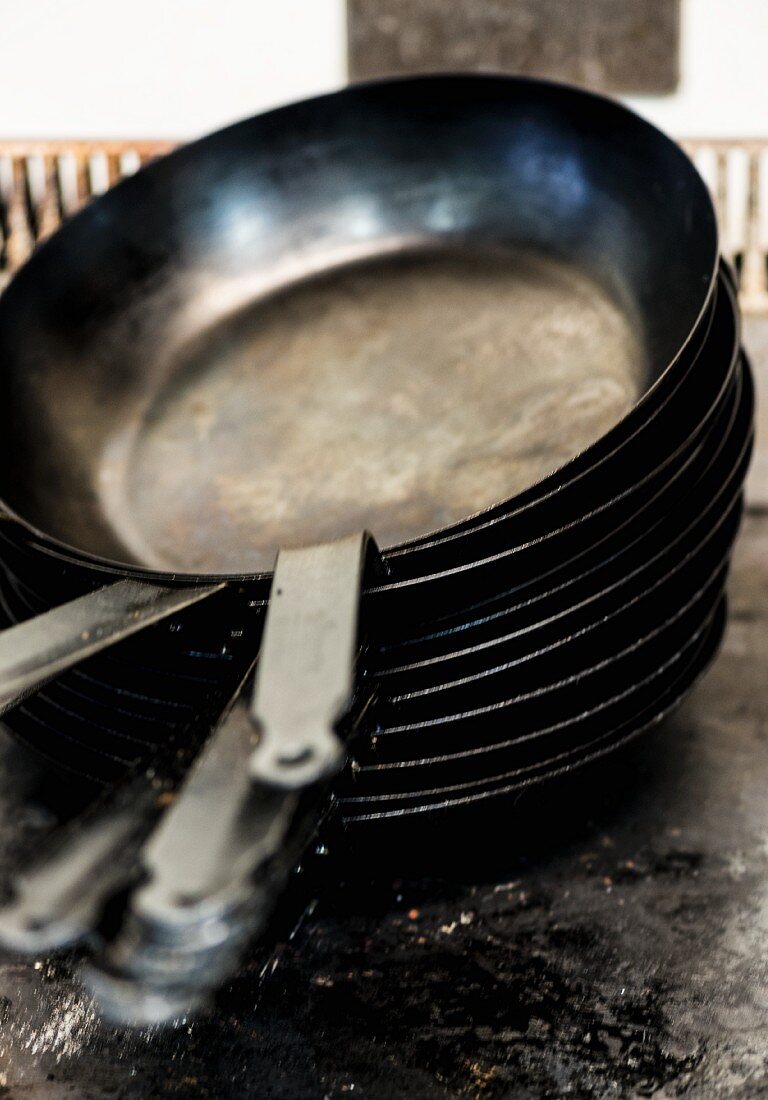 A pile of empty frying pans