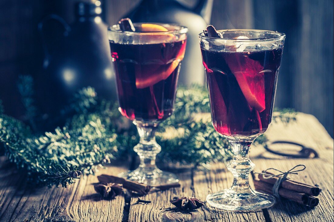 Zwei Gläser Glühwein mit Gewürznelken, Zimt und Anis zu Weihnachten