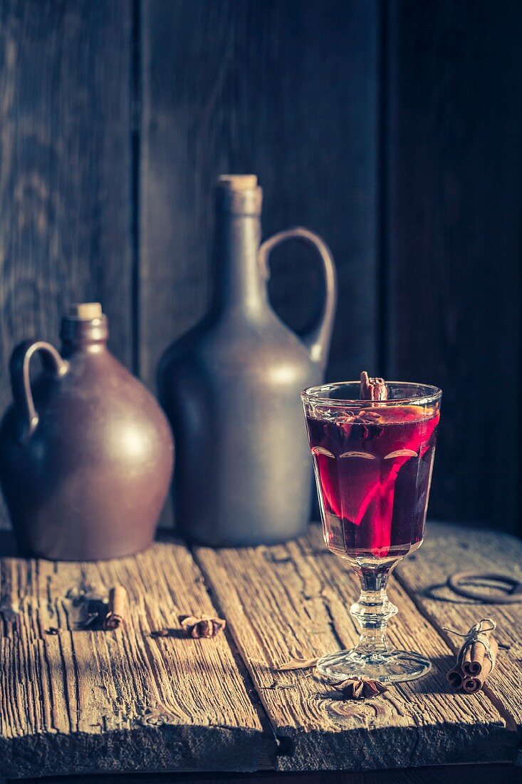 A glass of mulled wine on a rustic wooden table for Christmas