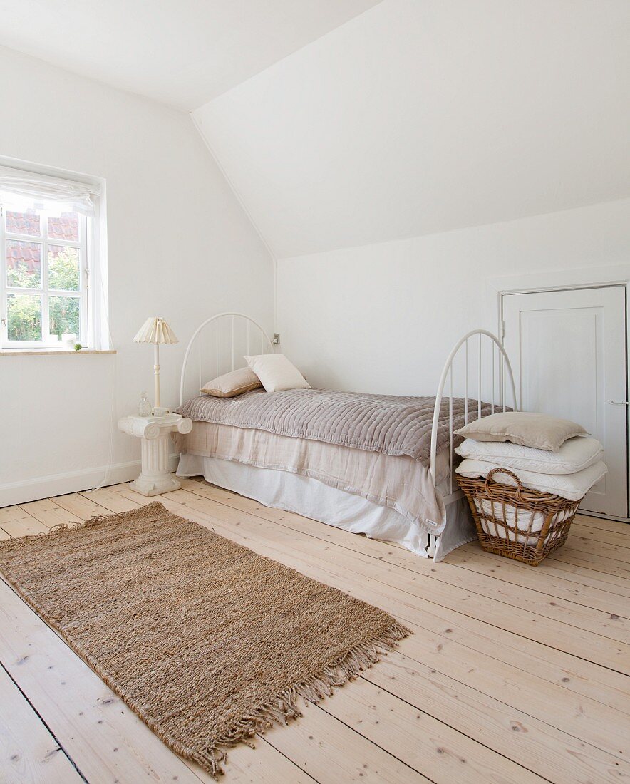 Attic bedroom in natural shades with fitted cupboard in jamb wall