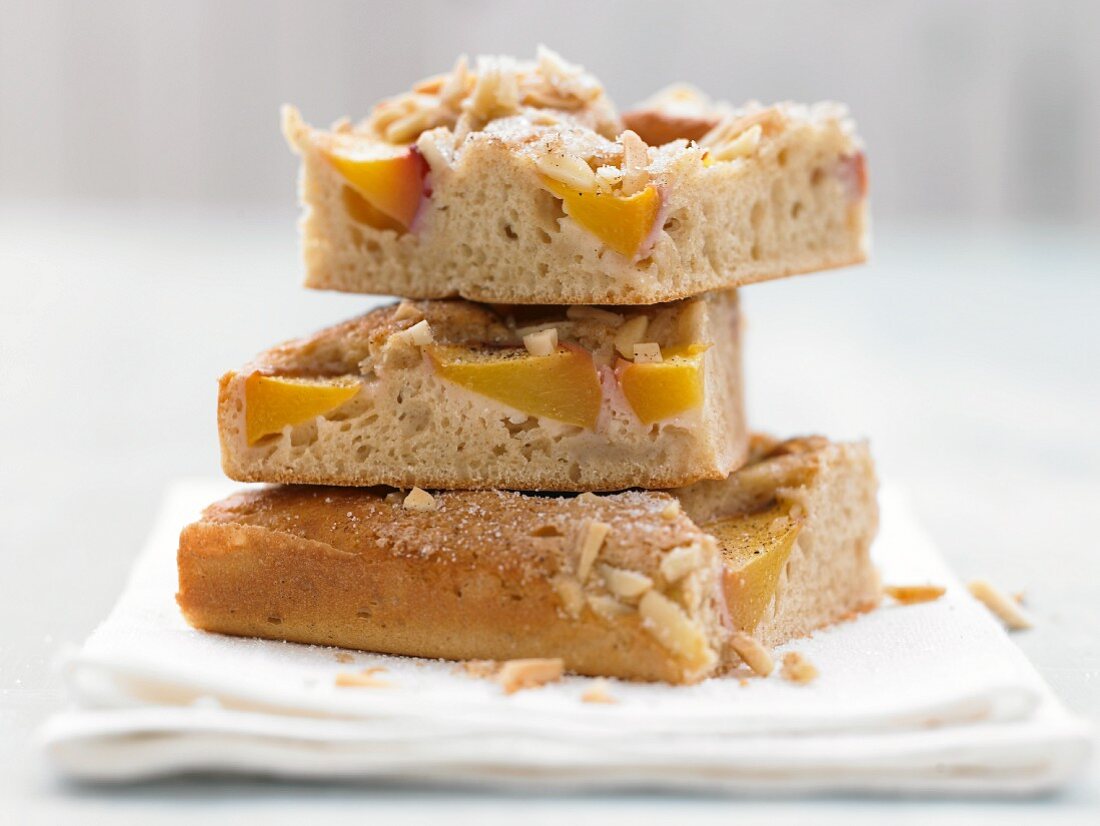 Peach cake on a plate with buttermilk and almonds