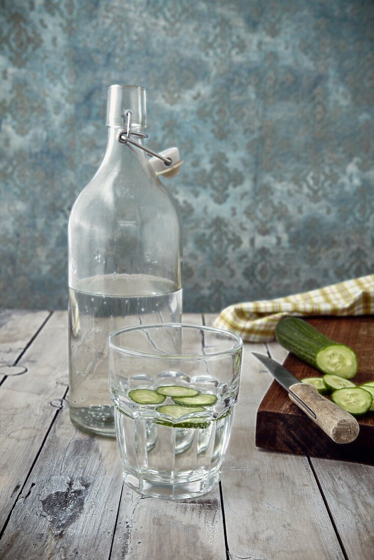 Glas Gurkenwasser, Wasserflasche und frische Gurke