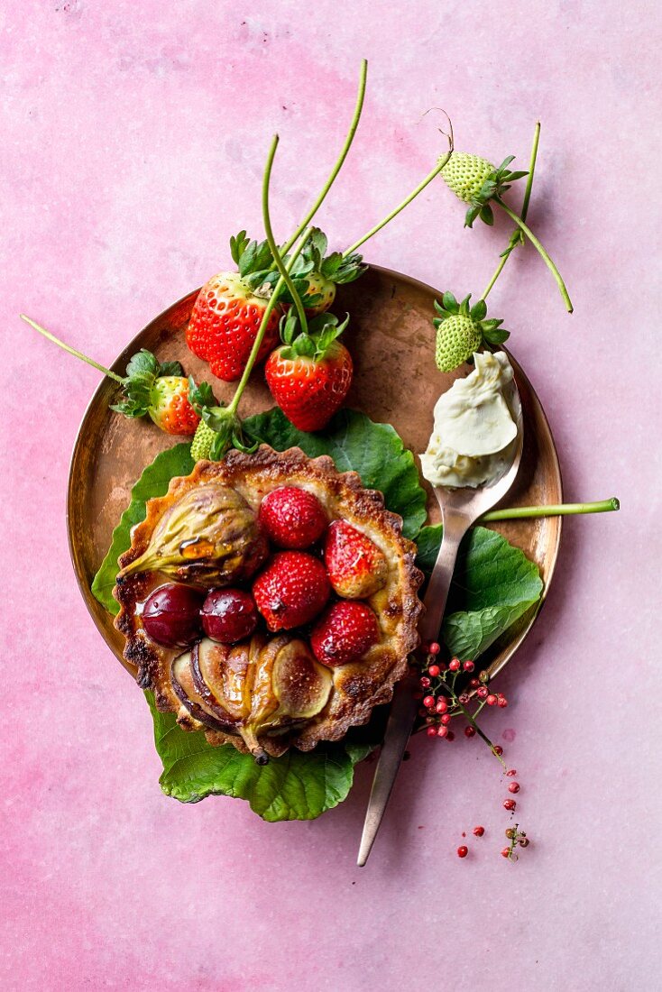 A fruit tartlet with berries, figs and pink peppercorns