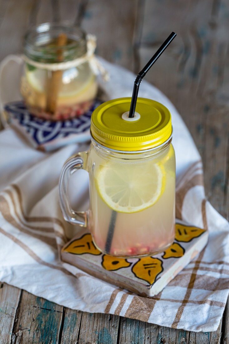 Lemonade with fresh lemon, mint, cinnamon and quince on a wooden surface