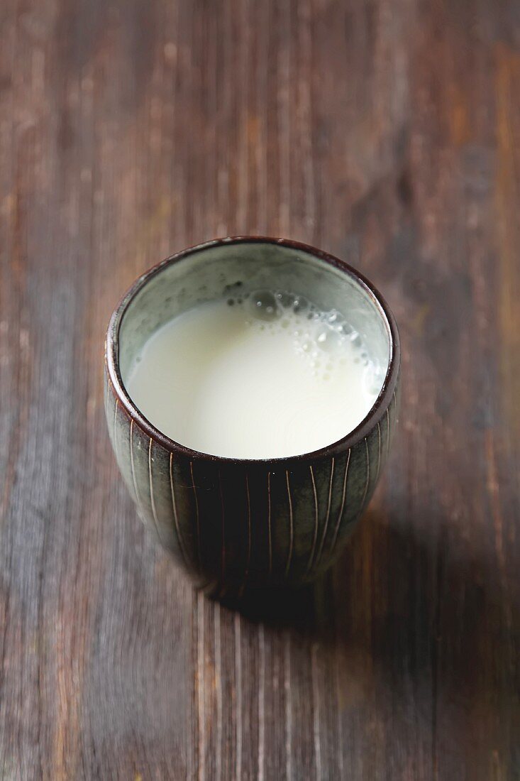 A vintage glass of milk on a wooden surface