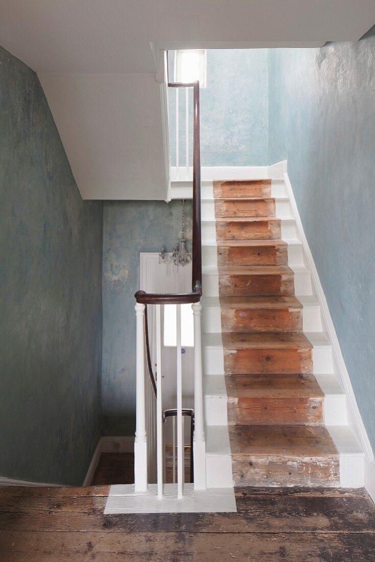 Rustikales Treppenhaus mit teilweise gestrichener Treppe