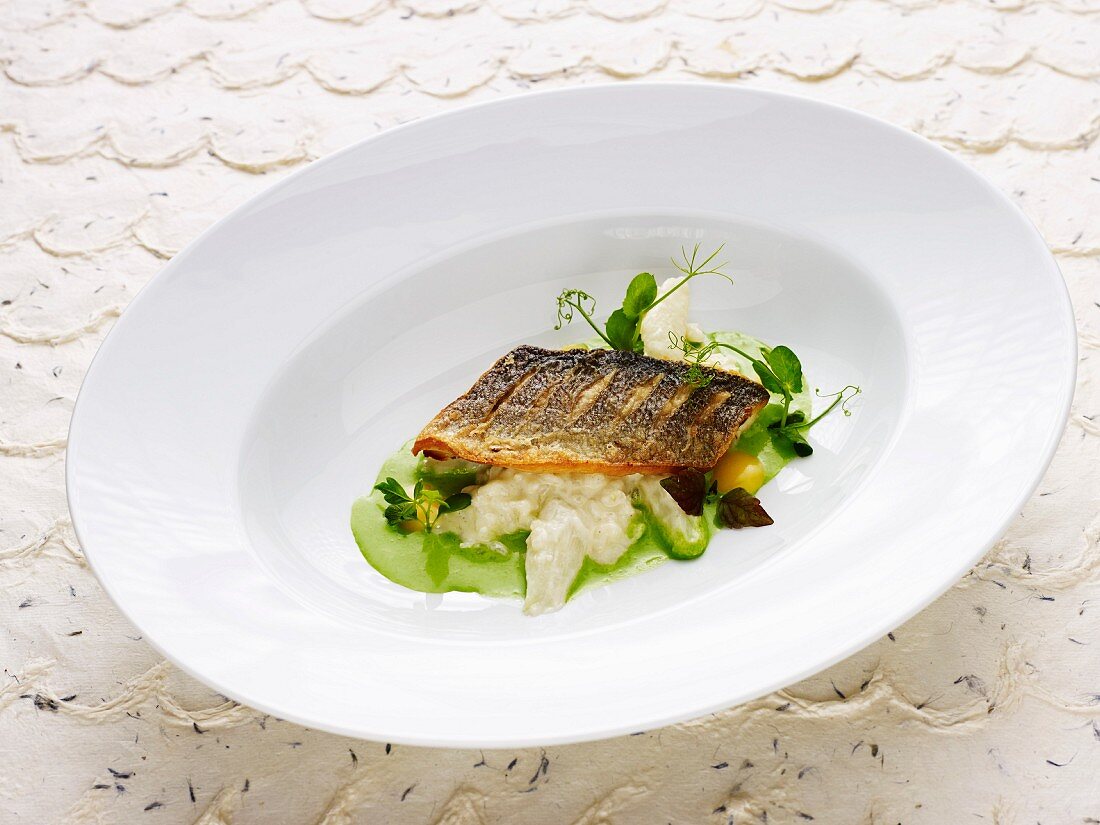 Asparagus risotto with pan-fried bass on parsley broth