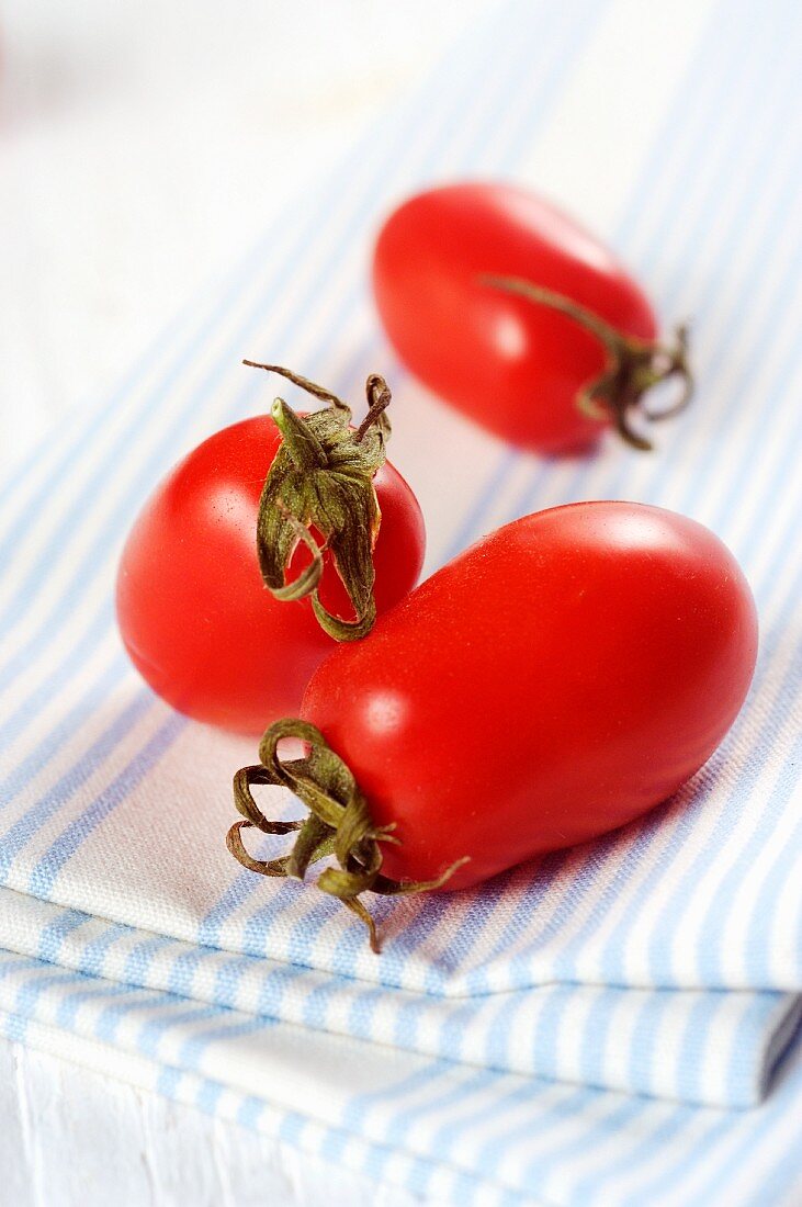 Three date tomatoes on a tea towel