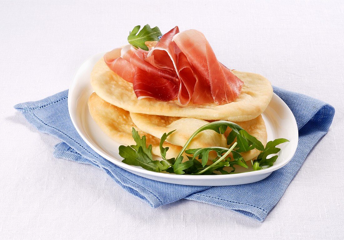 Gnocco fritto (fried Italian flatbreads) with cured ham and rocket