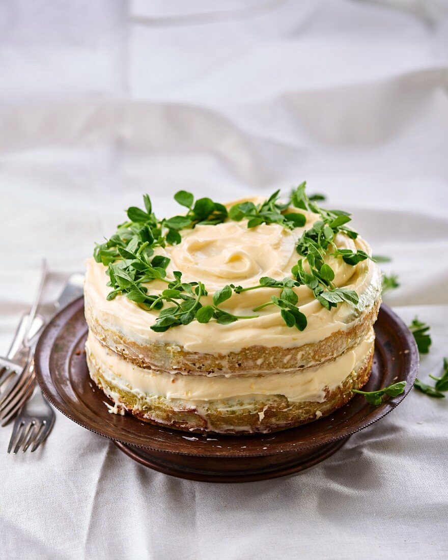 A sweet pea cake with lemon cream cheese cream and pea shoots