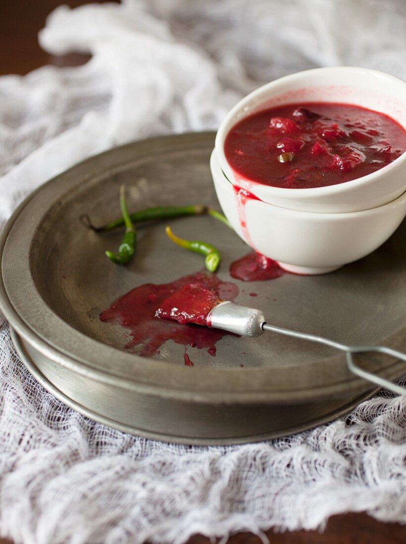 Hot plum sauce with chilli in a bowl on a metal plate