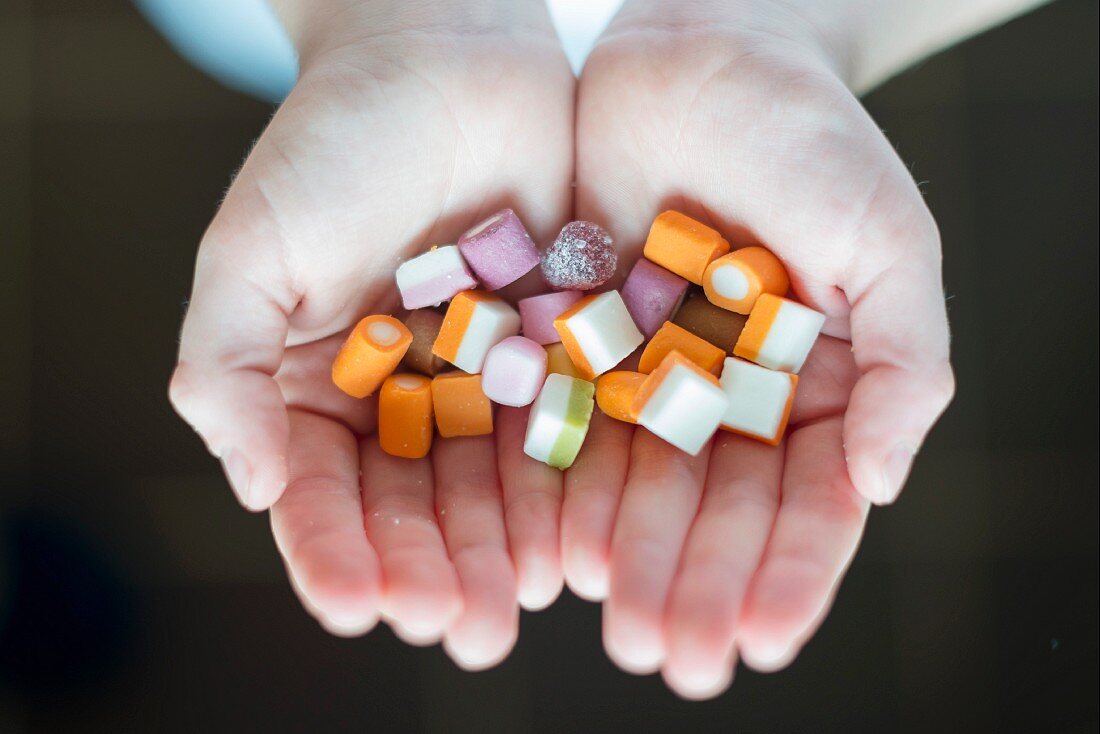 A child's hands holding sweets