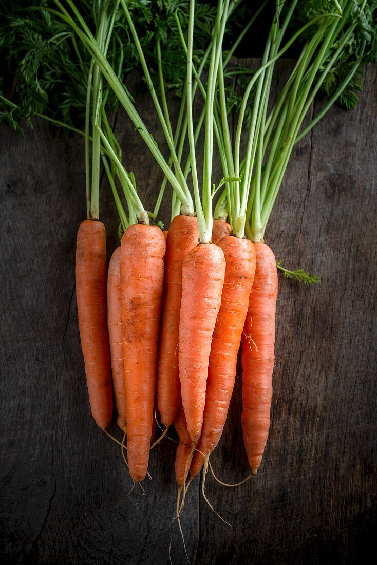A bunch of carrots on a wooden board