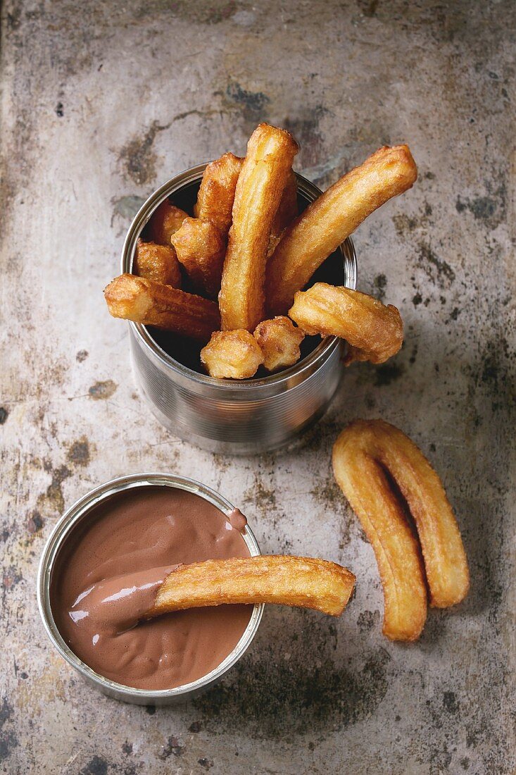 Spanish churros with chocolate sauce served in a tin can