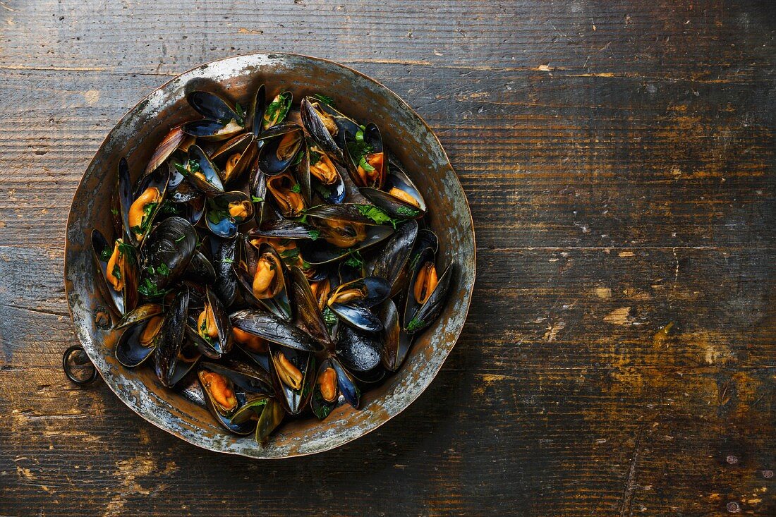 Mussels with parsley on wooden background