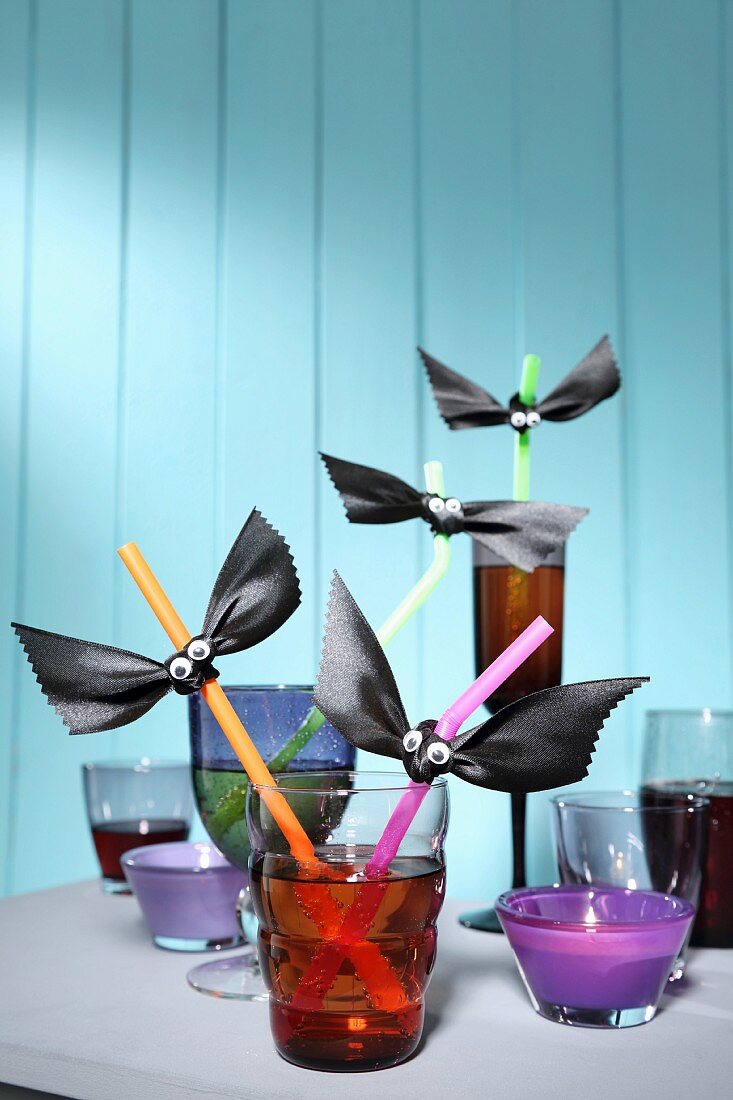 Various glasses with drinking straws decorated for Halloween party
