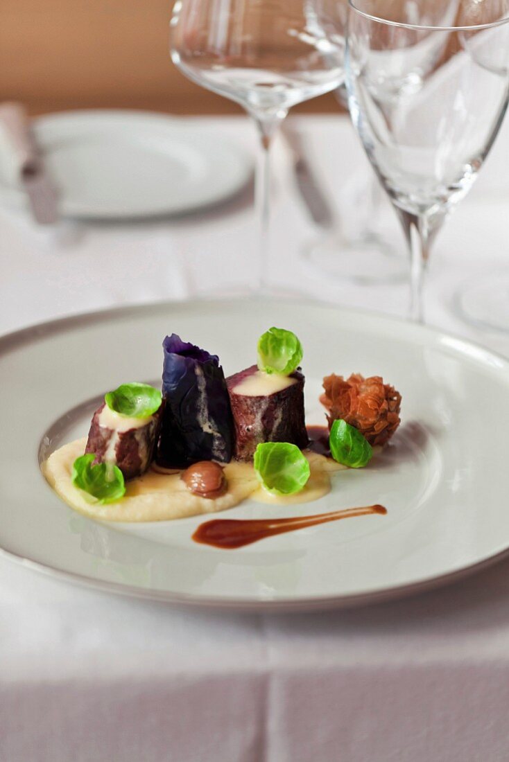 Venison loin served with red cabbage, chestnuts Brussels sprouts and cauliflower puree