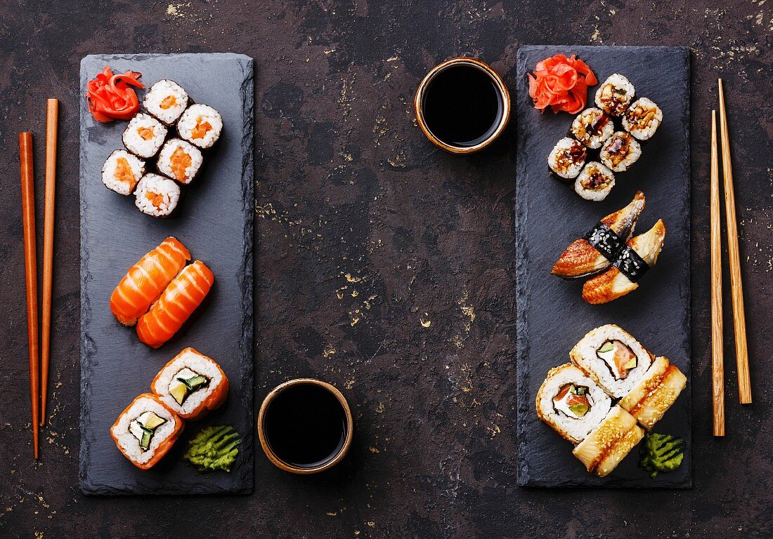 Assorted sushi (Maki and Nigiri) for two on a dark surface