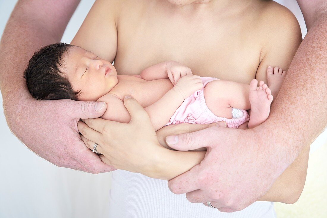 Parents cradling newborn baby girl