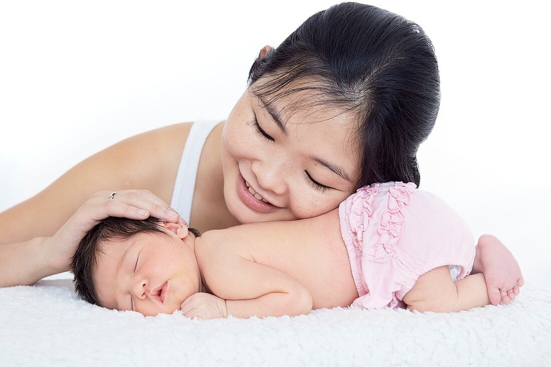 Mother stroking newborn baby girl's head