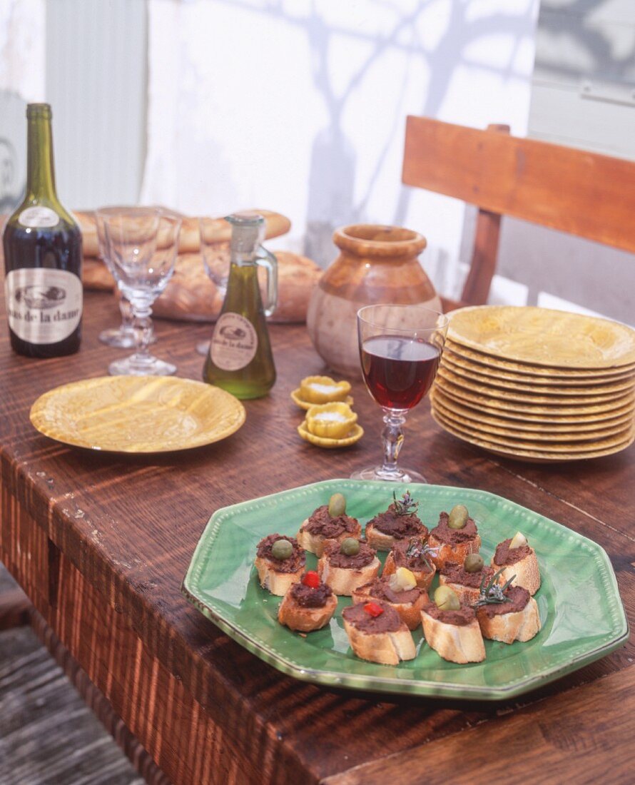 Crostini mit Tapenade auf rustikalem Tisch