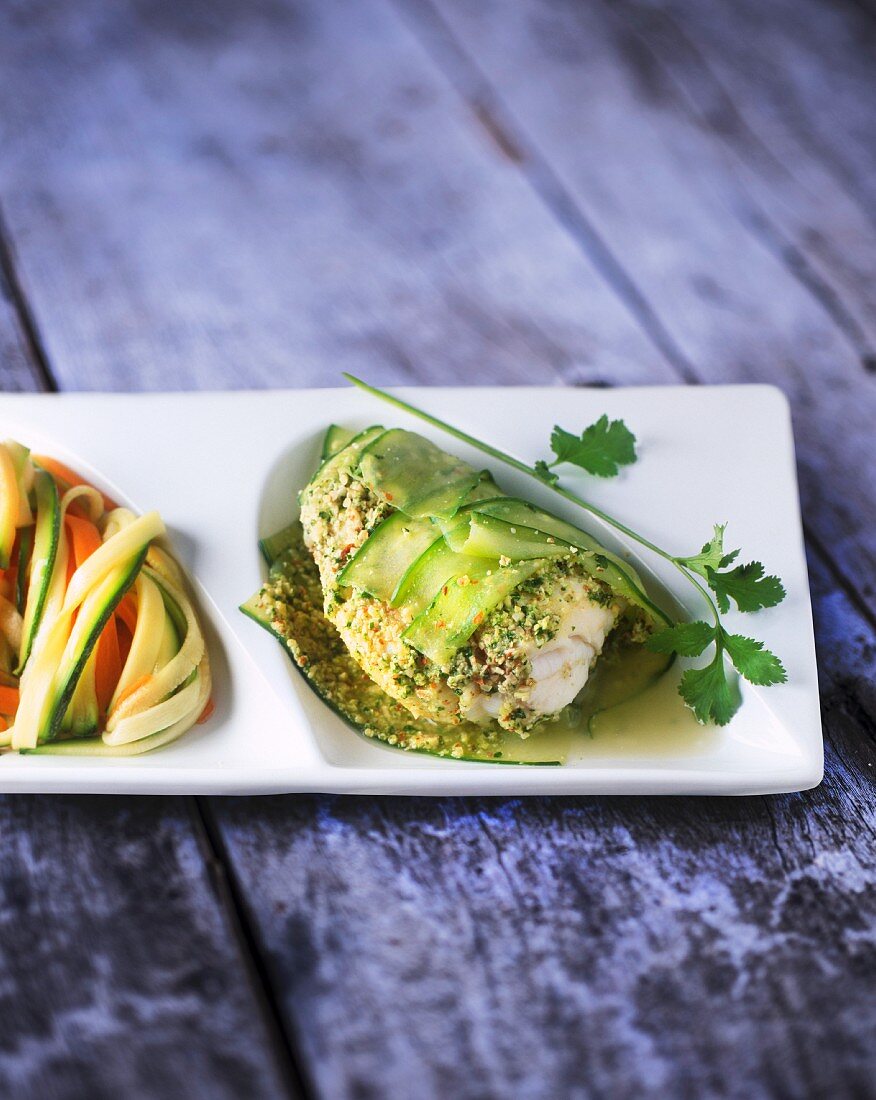 Fish wrapped in cucumber and served with colourful pasta