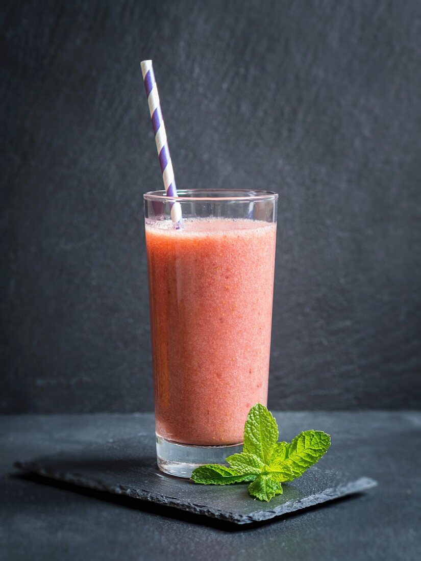 Milchfreier veganer roter Frucht-Smoothie im Glas mit Strohhalm