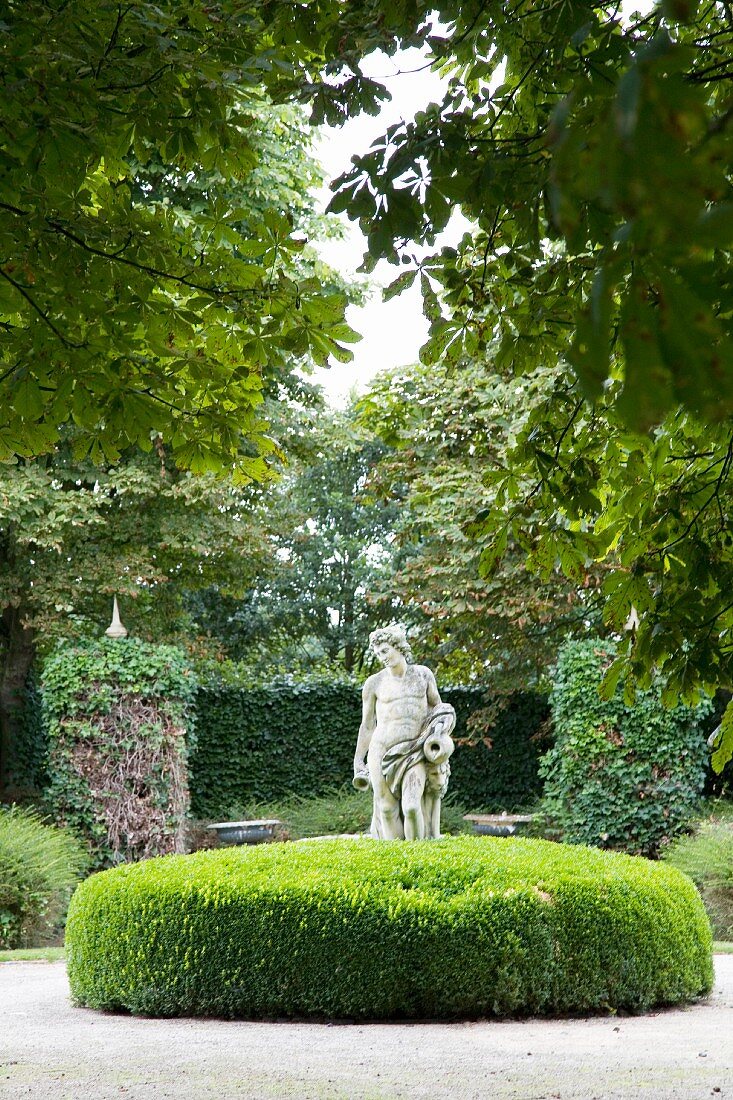 Bright green island of box with central statue