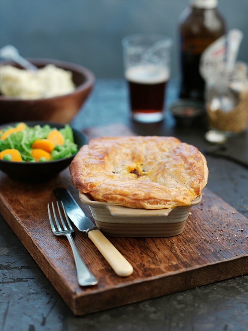 A whole steak pie in a casserole dish