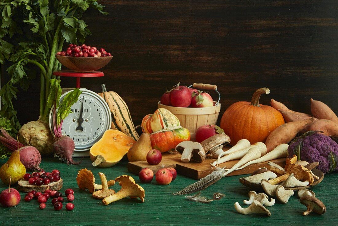An arrangement of autumn vegetables, mushrooms, fruit and an old pair of kitchen scales