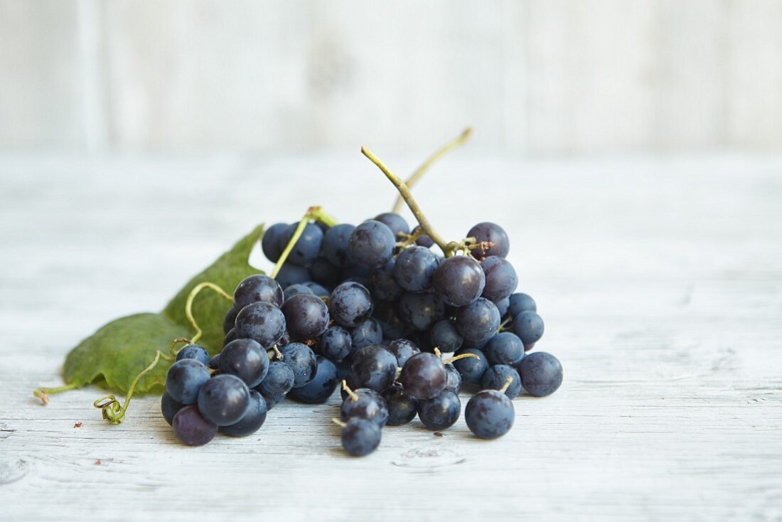 Fresh Concord grapes on a wooden surface