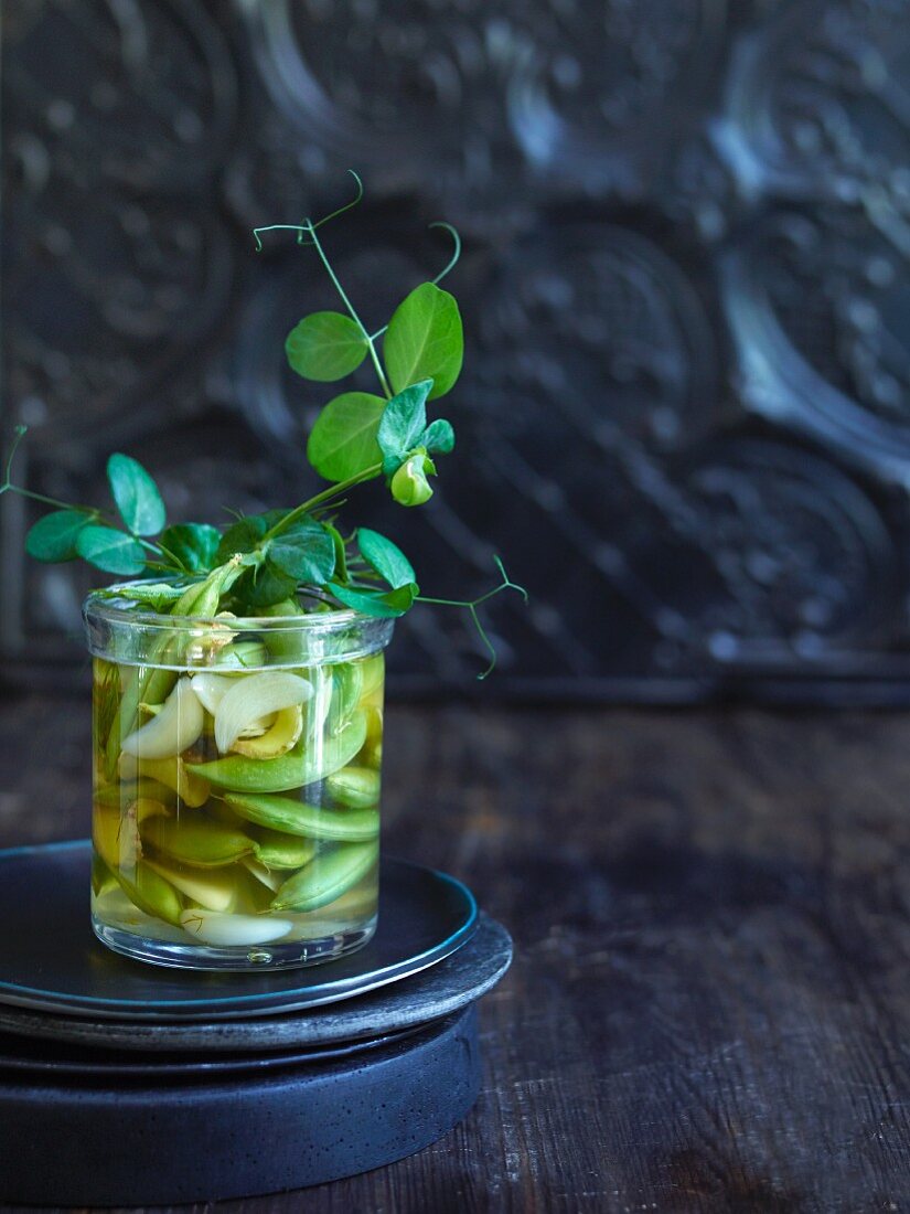 Pickled sugar snap peas with ginger and garlic in a glass