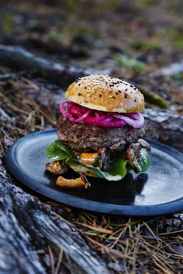 A burger with red onions and wild mushrooms